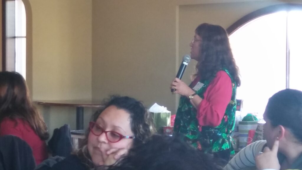 Annual Staff Holiday Party 15 a woman holding a microphone in front of a woman