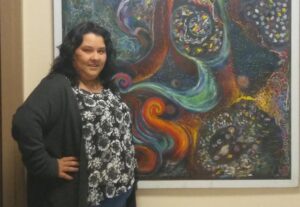 a woman standing in front of a painting