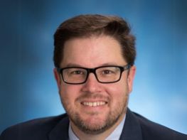 a man wearing glasses and a suit