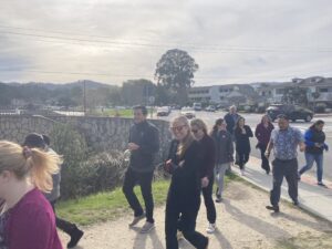 a group of people walking on a sidewalk