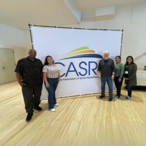 a group of people standing in front of a white board
