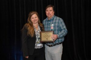 a man and woman holding a plaque