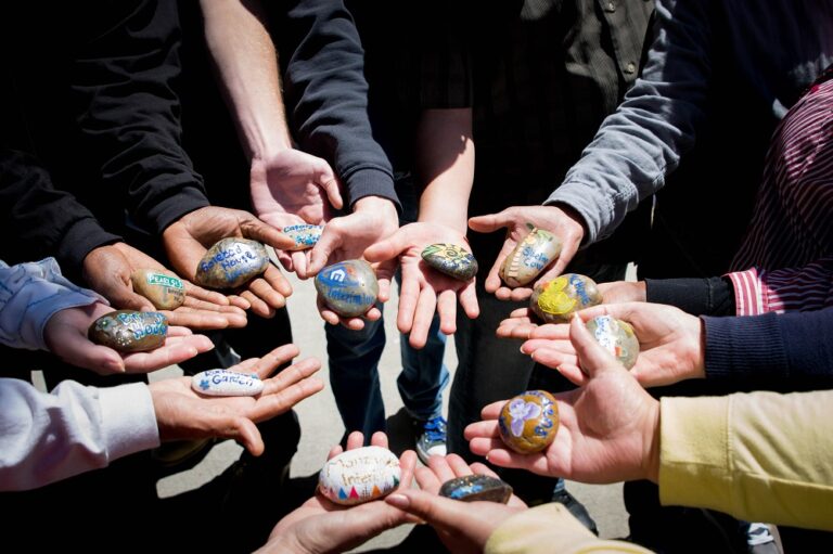 a group of people holding rocks with writing on them