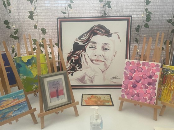 art on a table with easels and paintings
