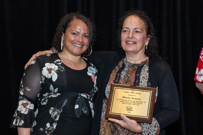 two women holding a plaque
