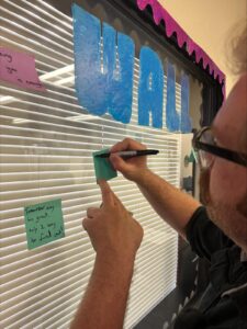 a man writing on a window