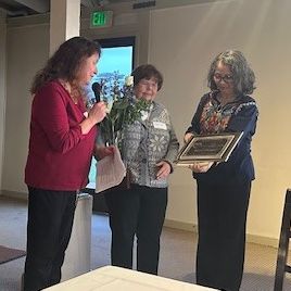 a group of women holding a microphone and a picture
