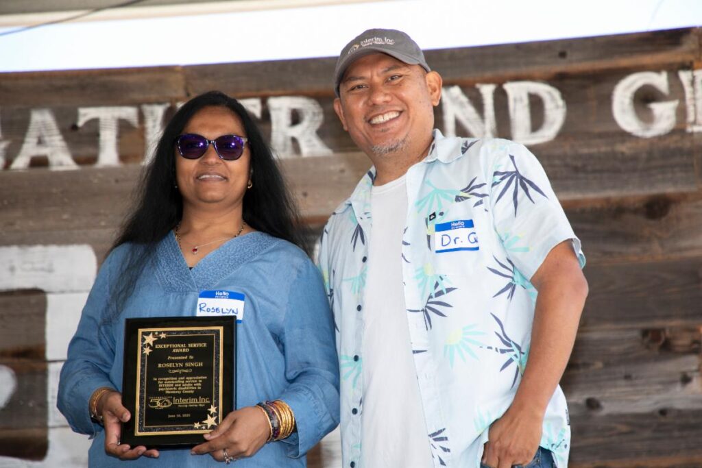a man and woman holding a plaque